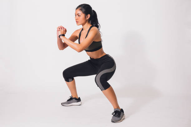 Young sporty muscular woman doing squats