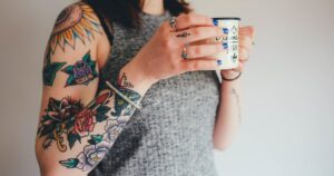 tattooed girl holding a mug