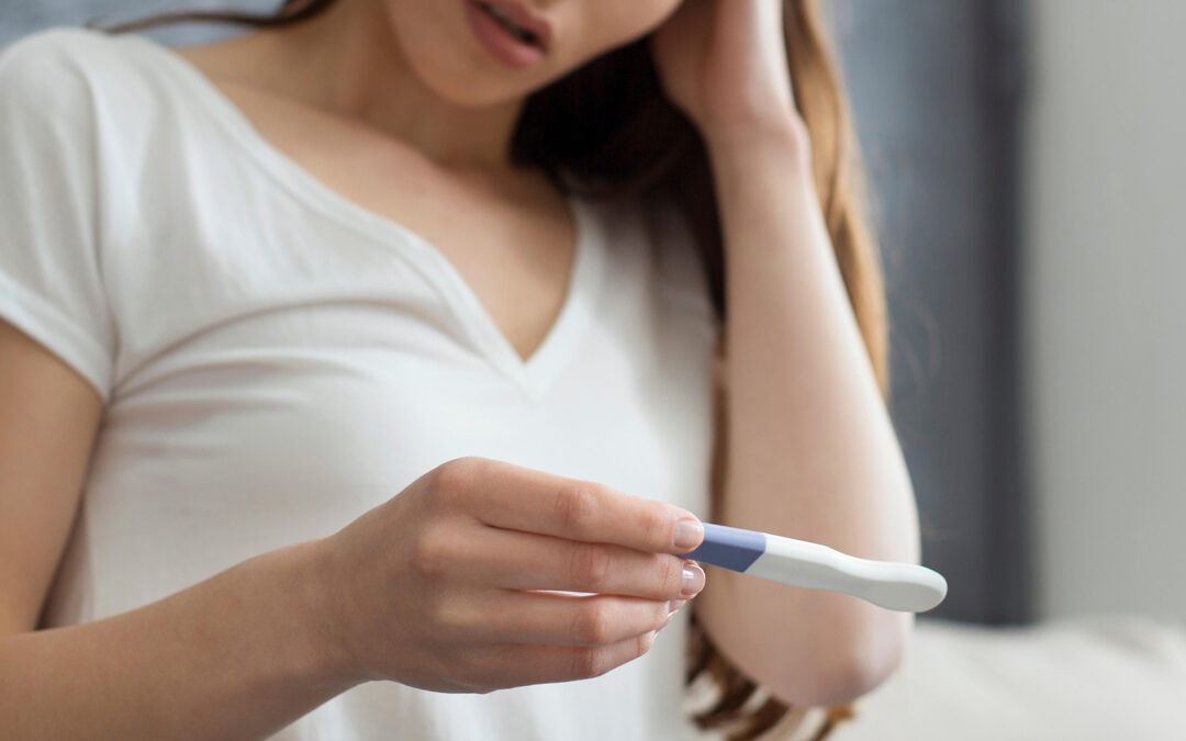 disappointed woman holding pregnancy test