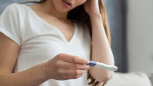 disappointed woman holding pregnancy test
