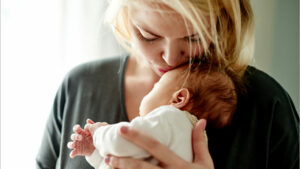 a woman holding and kissing her baby